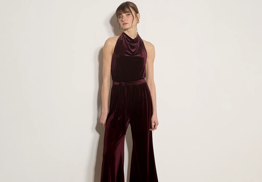 Model is a red velvet jumpsuit