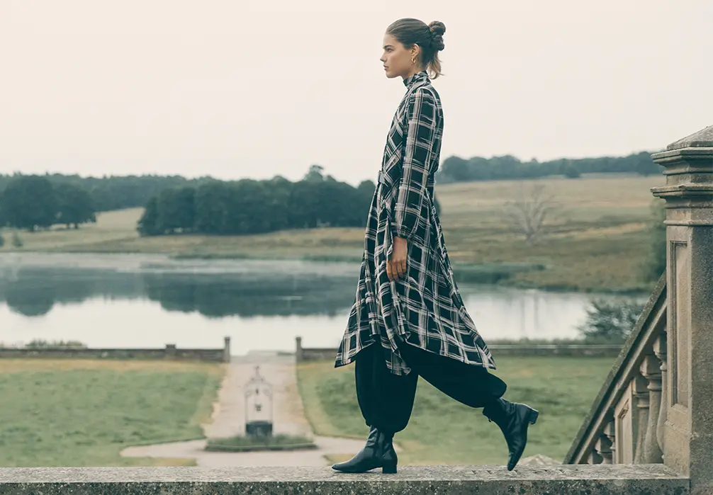 Model is wearing a flowy check patterned black and white dress
