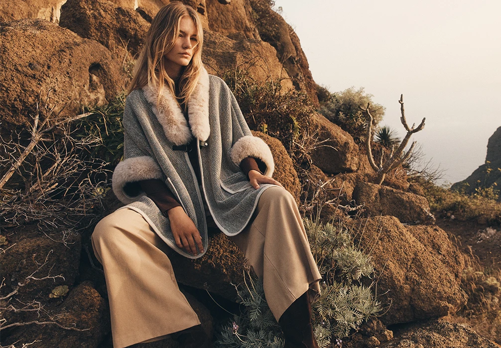 A girl standing in a dress. Text on image: Get set for the season ahead with the latest women’s clothing at Apricot. Discover versatile mini dresses, midi dresses & maxi dresses designed to take you from work to the weekend. On colder days, shrug on a cosy cardigan or a chill-defying chunky knit jumper. Give your separates a seasonal refresh with knitted tops, T-shirts, and denim jeans in flattering flare, skinny, and straight-leg cuts. Update your outerwear collection with practical parkas, puffer jackets, & raincoats. Shop new-in women’s clothing at Apricot now.